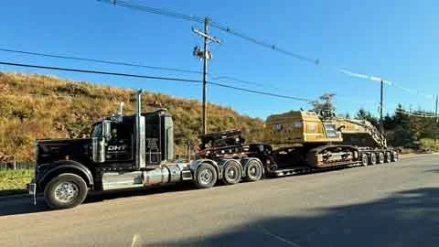Dave's heavy hauler carrying an excavator on a lowboy trailer
