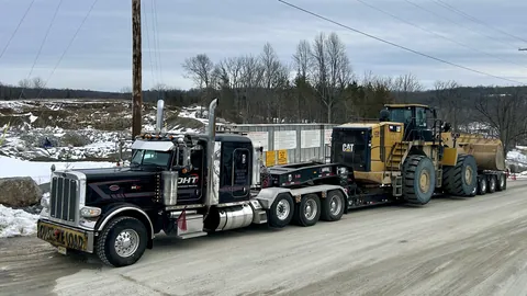 Heavy hauler carrying a wheel loader in the snow