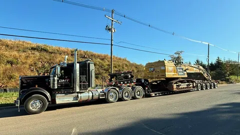 Heavy haul tractor and lowboy carrying a track excavator